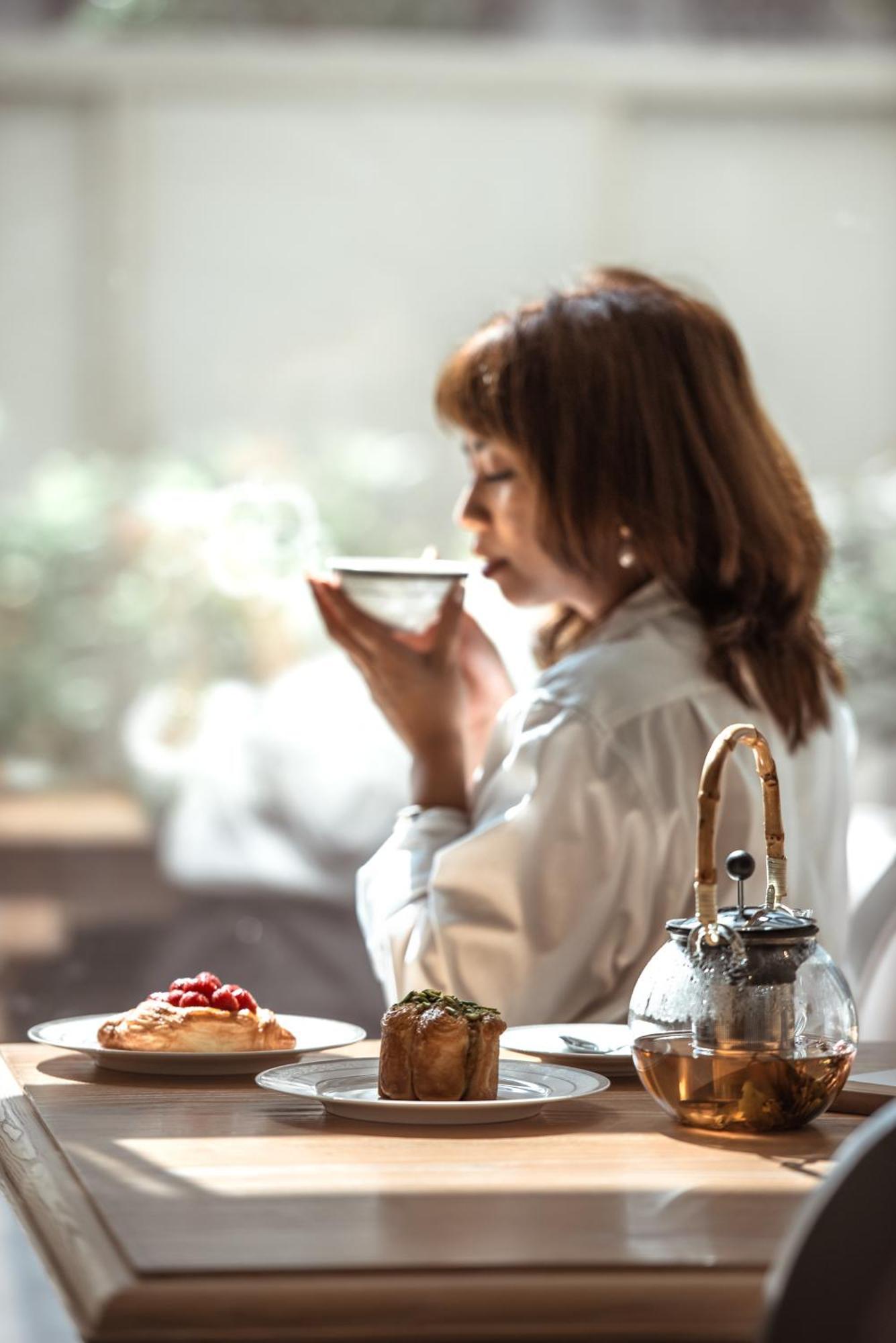 Dusit Doha Hotel Esterno foto A woman drinking tea
