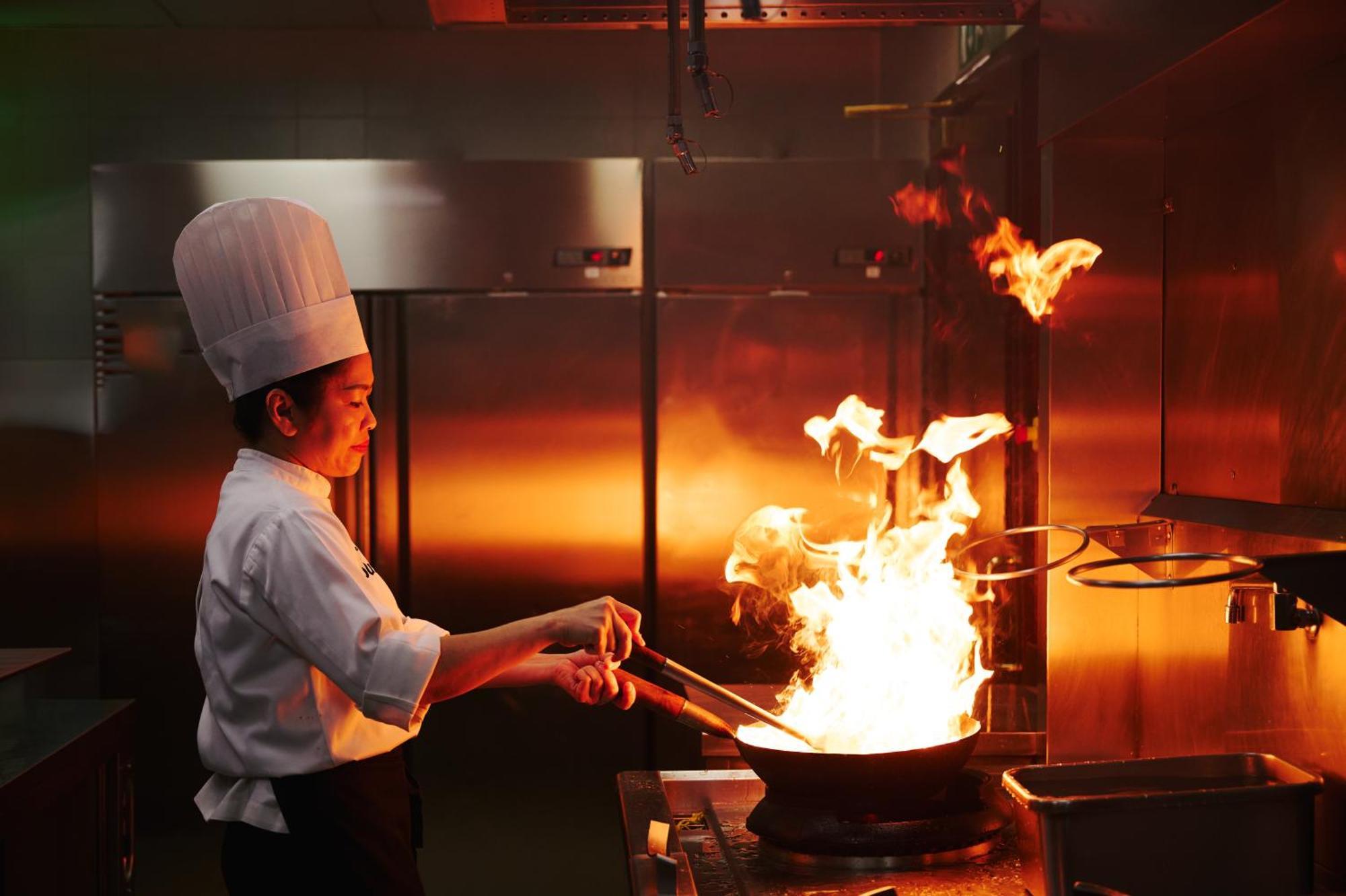 Dusit Doha Hotel Esterno foto A chef cooking with a wok